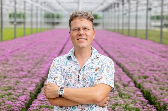 Picture of Maarten Casteleijn in greenhouse with flowers