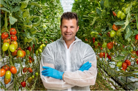 Picture of Martijn Maat in greenhouse in between plants